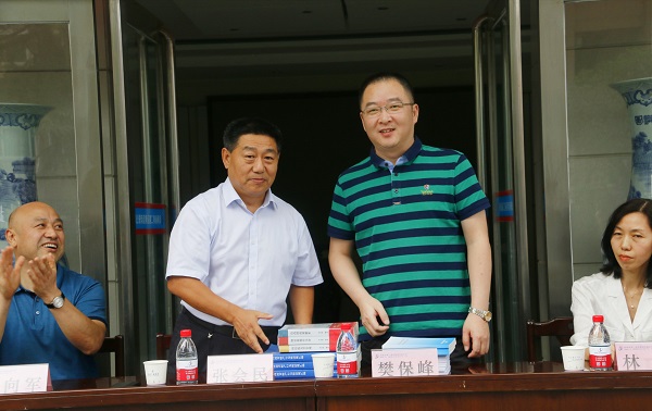新乡市牧野区税务局党委书记、局长樊保峰向买球(中国)党委书记张会民赠送税法知识书籍.jpg